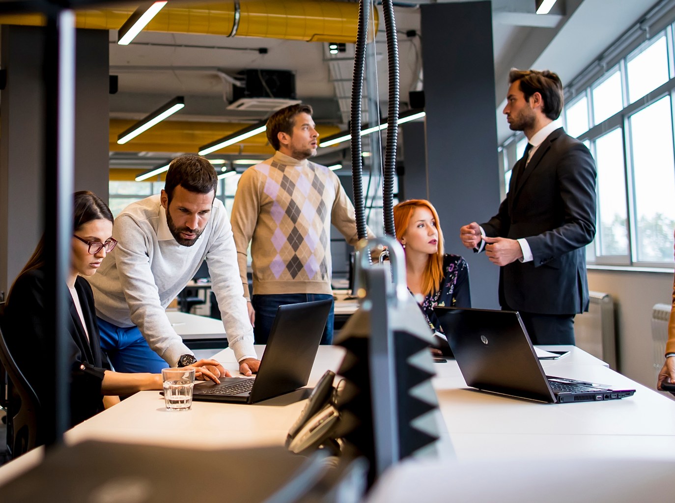 Team van Mobile XL in overleg rond een bureau op kantoor