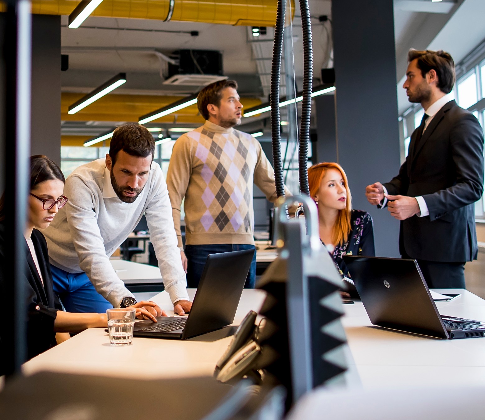 Team overlegt samen bij laptops in een modern kantoor